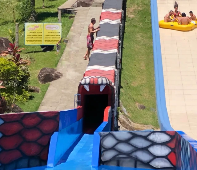 Vista do final da atração Tobo Cobra, um toboágua fechado e reto com pintura de cobra coral.